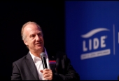 Foto com a imagem do economista Marcelo Neri no evento e ao fundo a logo do LIDE - Grupo de Líderes Empresariais