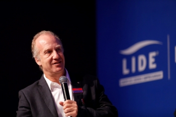 Foto com a imagem do economista Marcelo Neri no evento e ao fundo a logo do LIDE - Grupo de Líderes Empresariais